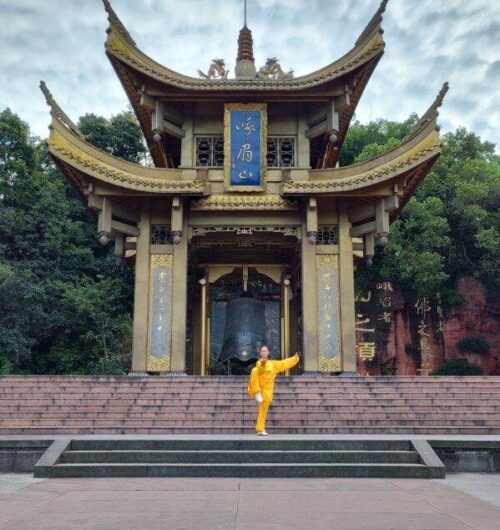 Nelly Rovira holding a tai chi pose in front of a Chinese temple